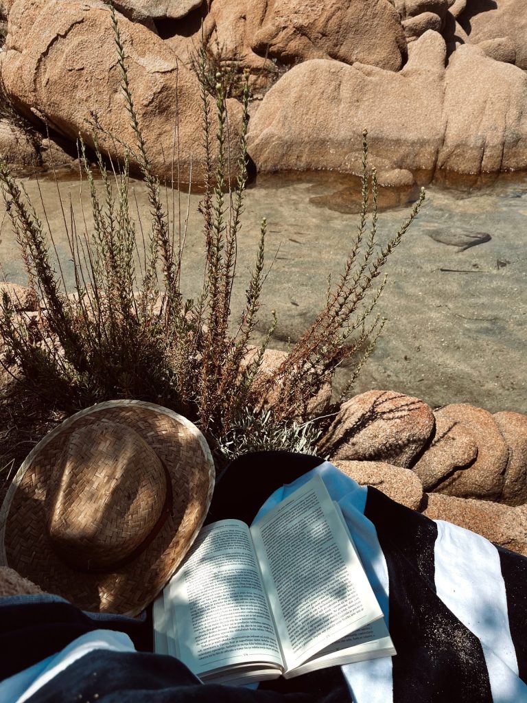Knjiga na peskiru pored mora kao simbol mira i opustanja